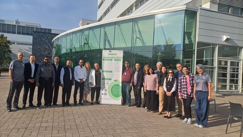 The KODECET team in front of a university building next to the project banner